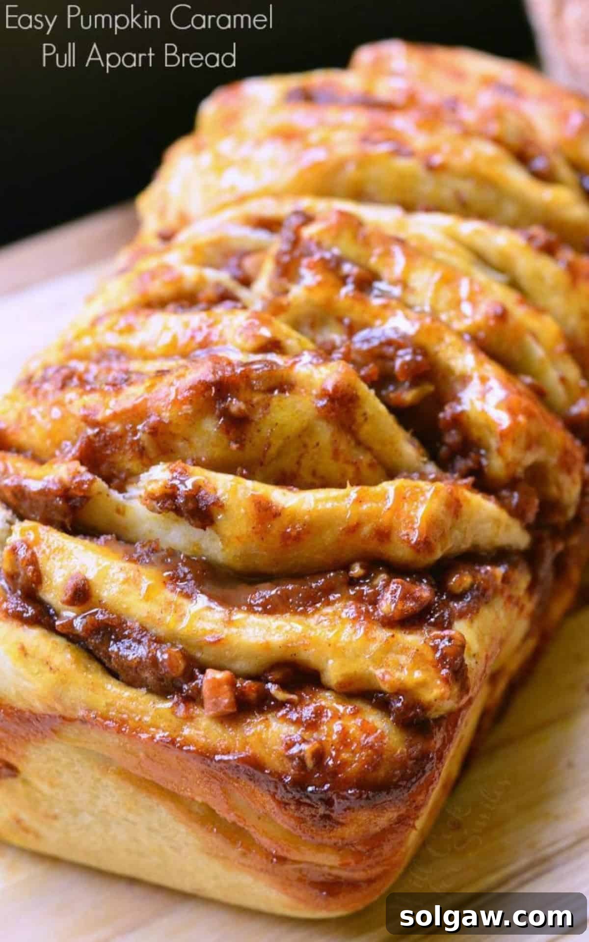 Spiced Pumpkin Pull-Apart Loaf 2 juicy pumpkin pull apart bread with caramel on top on a cutting board and title.