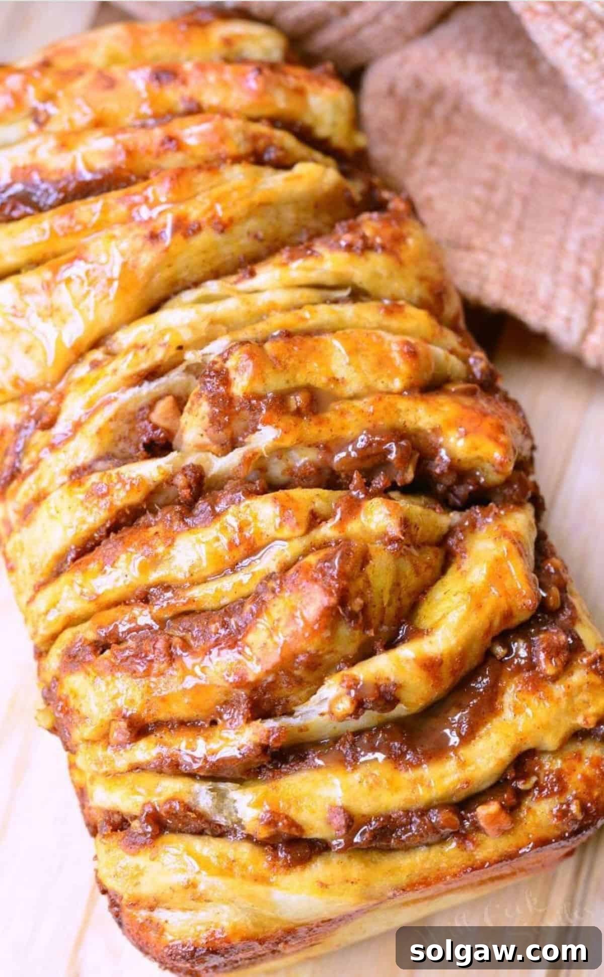 Spiced Pumpkin Pull-Apart Loaf 8 load of pumpkin pull apart bread drizzled with caramel on wooden board.
