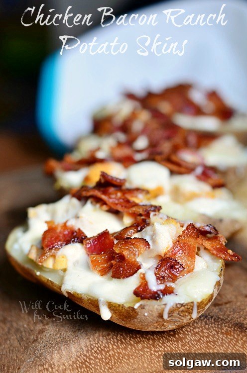 Zesty Fiesta Chicken Stuffed Potatoes 10 Crispy Chicken Bacon Ranch Loaded Potato Skins, richly topped with melted cheese, savory bacon bits, and fresh chives, served on a rustic cutting board.