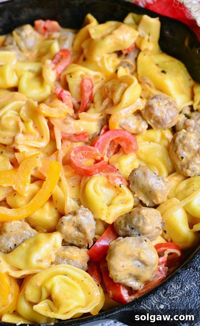 Ultimate Italian Sausage Lasagna 9 Sausage Peppers and Onion Tortellini served in a cast iron skillet, a comforting pasta dish.