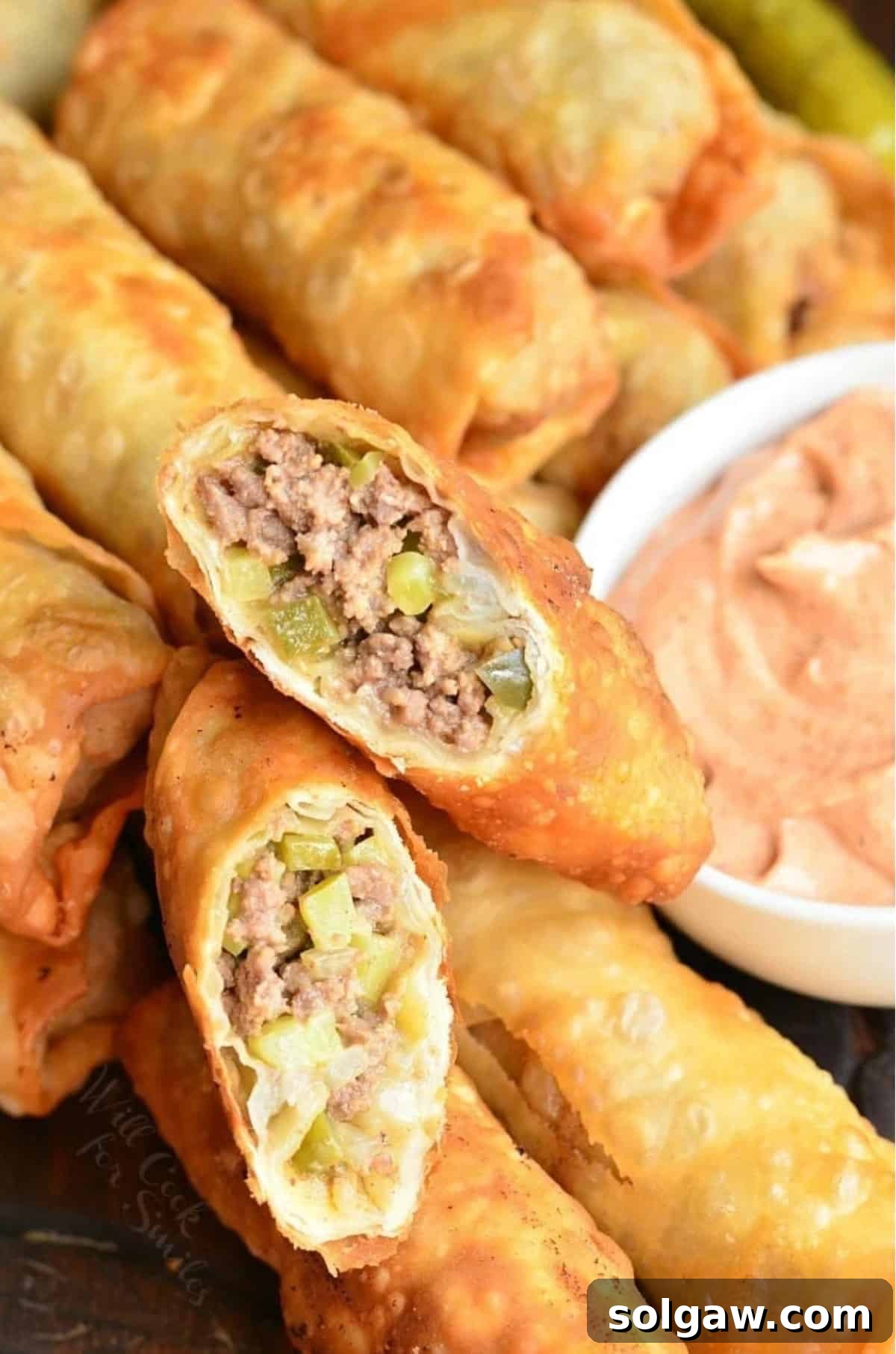 two cut halves of a cheeseburger egg roll on top of others side by side.