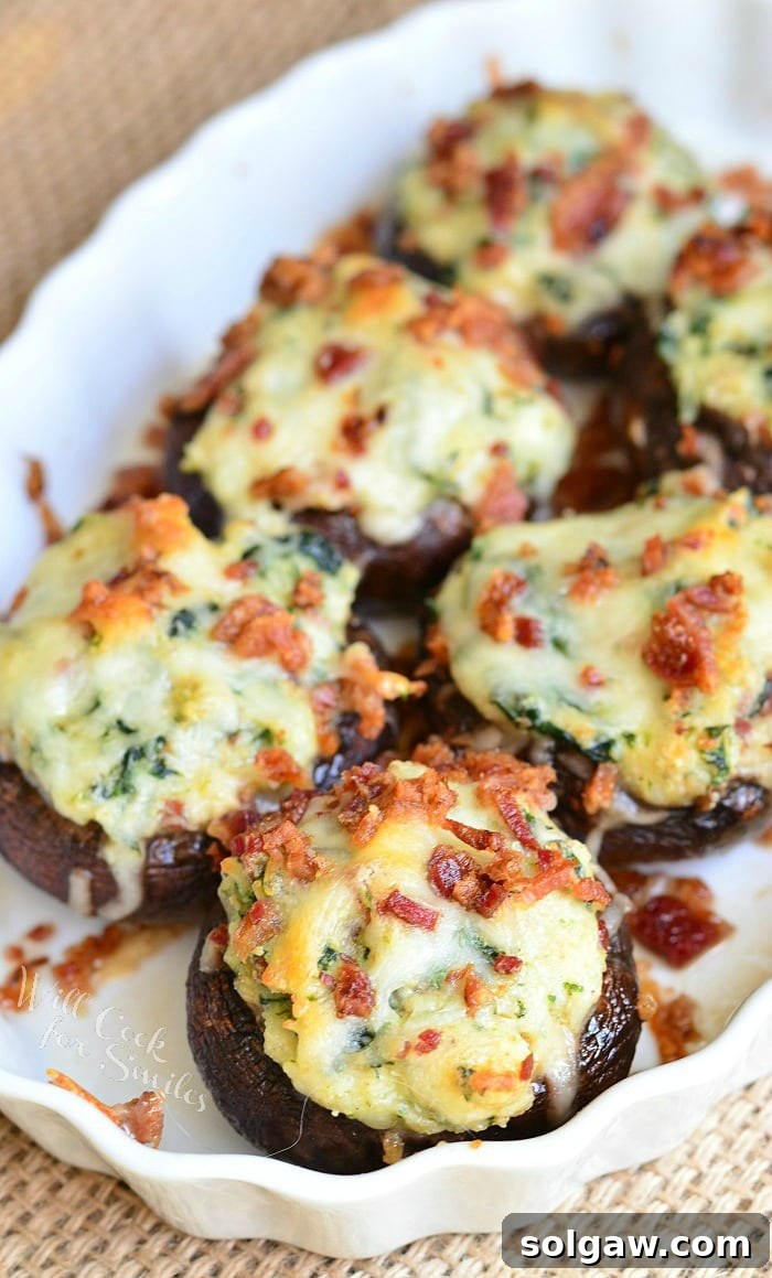 A large serving of bacon spinach and four cheese stuffed mushrooms