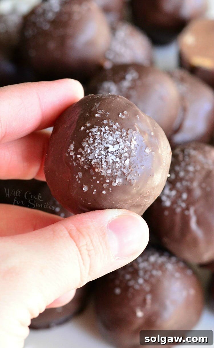 Holding a salted Almond Fudge Truffle