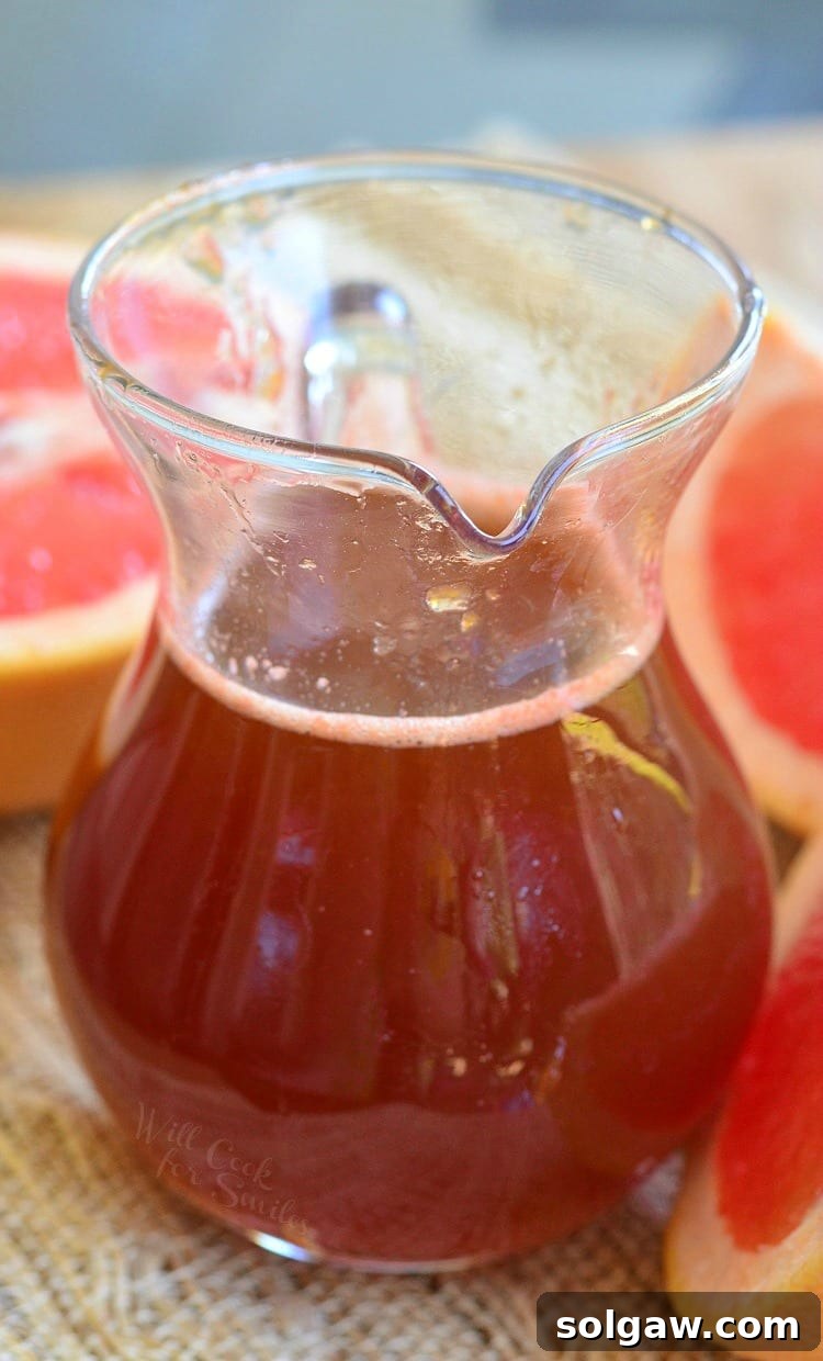 Homemade Grapefruit Syrup in a glass container, looking vibrant and inviting.