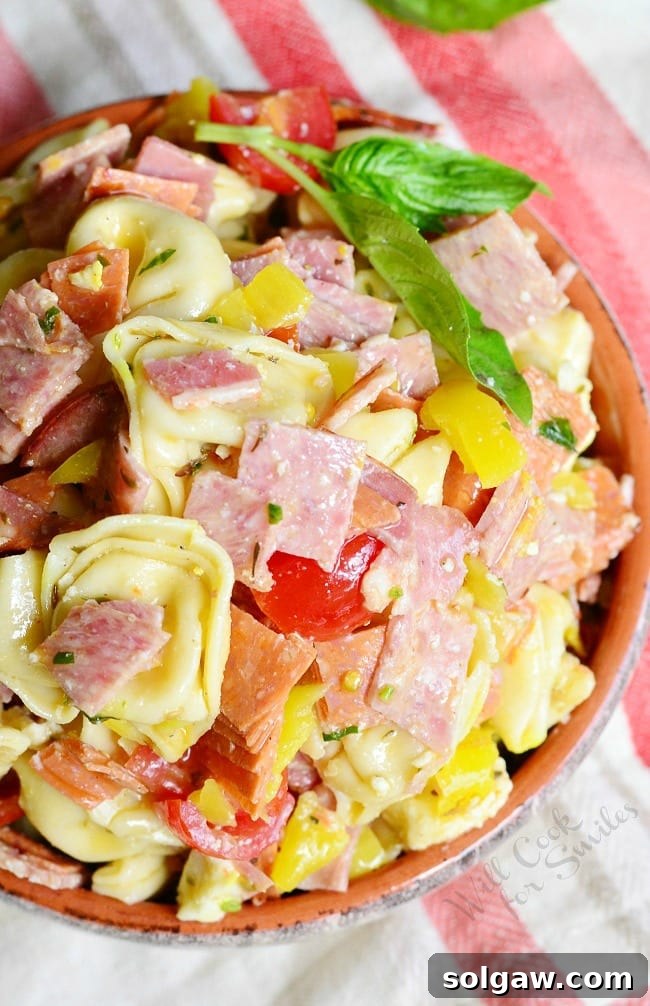 Italian Tortellini Salad with meats and tomatoes in a serving bowl.