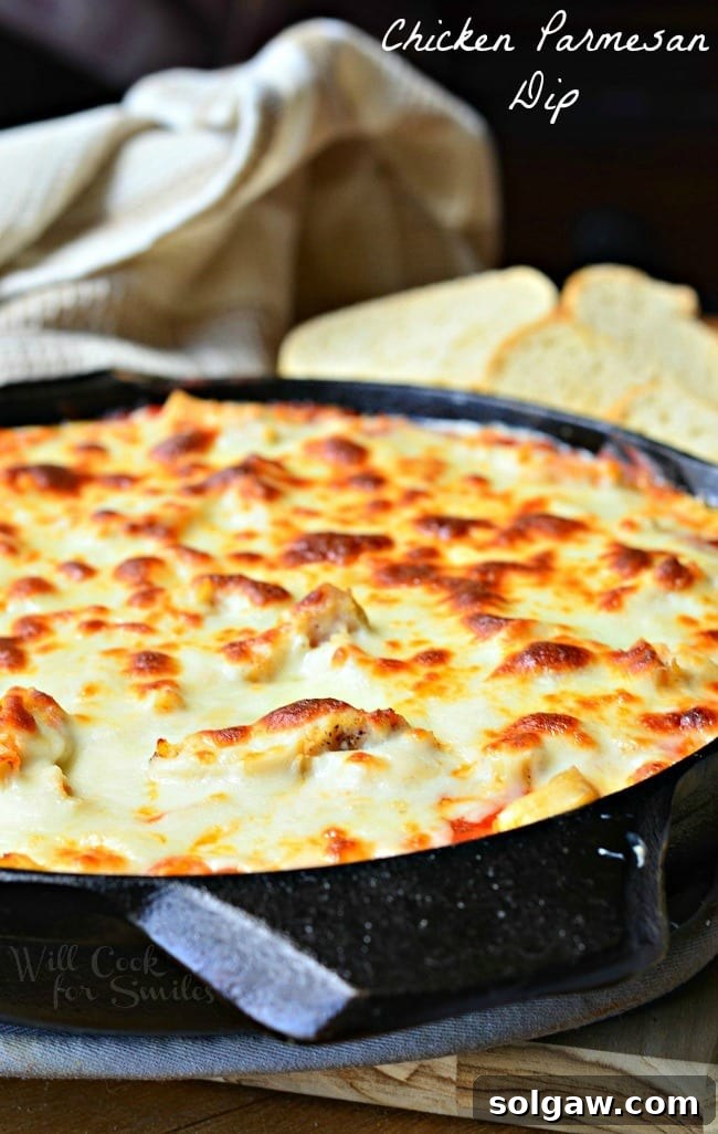 Creamy Chicken Parmesan Dip in a cast iron skillet with bread