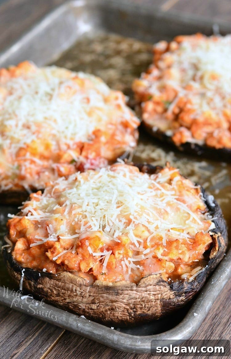 Close-up of a Chicken Parmesan Stuffed Portobello mushroom with melted cheese and fresh basil