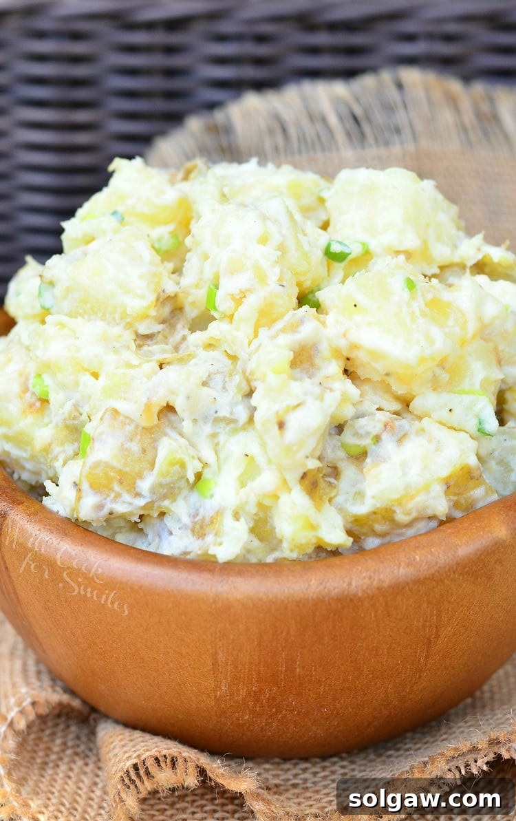 Savory Roasted Garlic Asiago Potato Salad 4 Wooden bowl filled with roasted garlic asiago potato salad on a tan cloth