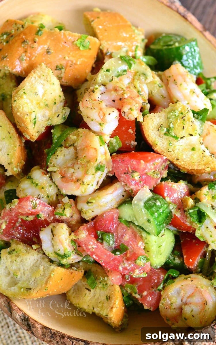 Top view Panzanella Salad with Shrimp, tomato, and cucumber, and bread with Pesto in a bowl 