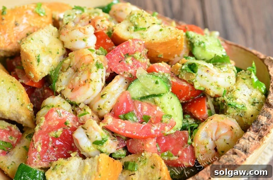 Panzanella Salad with Shrimp, tomato, and cucumber, and bread with Pesto in a bowl 