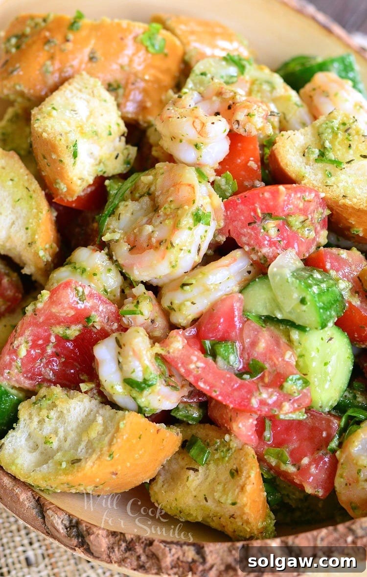 top view of Panzanella Salad with Shrimp, tomato, and cucumber, and bread with Pesto in a bowl 