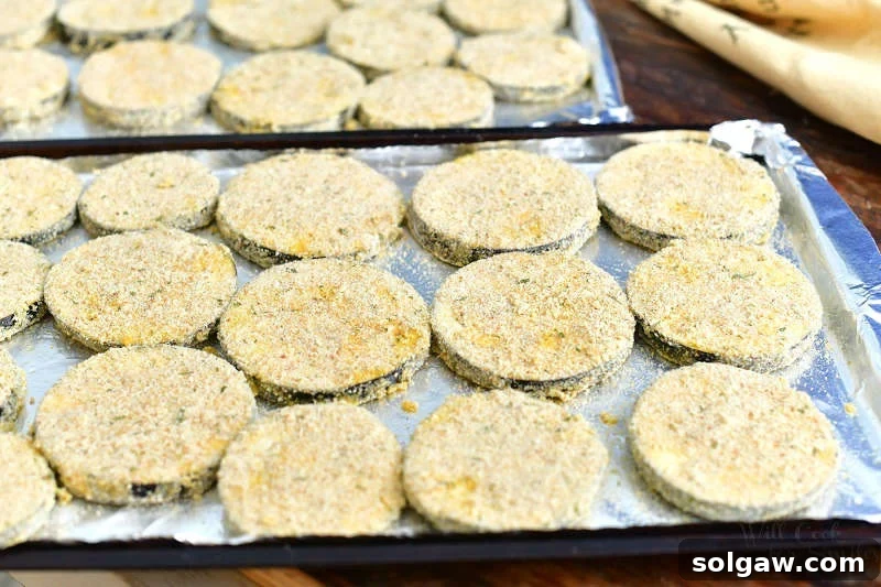 Irresistible Baked Eggplant Parmesan 3 breaded eggplant slices laid out in one layer on two baking sheets