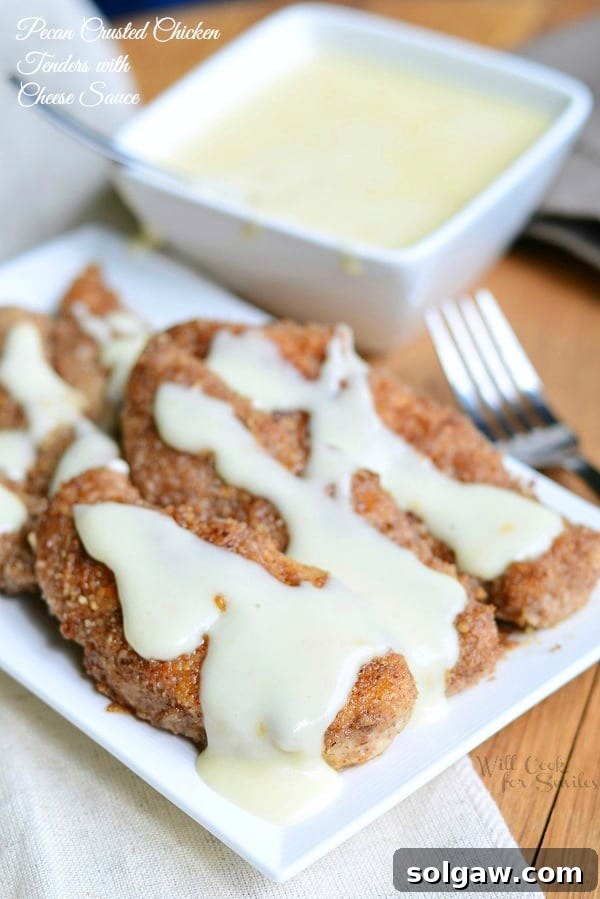Fiery Sriracha Chicken with Sweet Honey Dip 9 Pecan Crusted Chicken Tenders with Cheese Sauce over them on a white plate and the rest in a small bowl