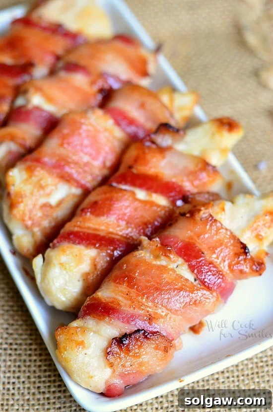 Fiery Sriracha Chicken with Sweet Honey Dip 10 Bacon Wrapped Chicken Strips on a white serving plate