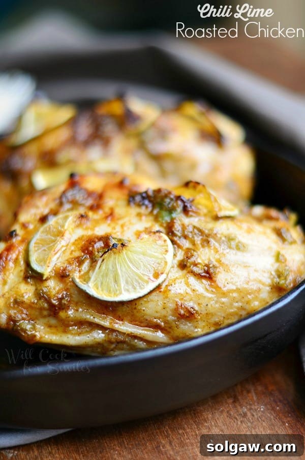 Chili Lime Roasted Chicken with fresh lime slices on top, served in a cast iron skillet.