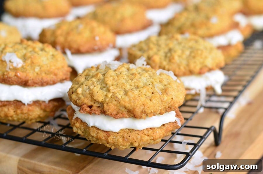 A close-up of freshly baked Coconut Oatmeal Cookie Sandwiches on a cooling rack