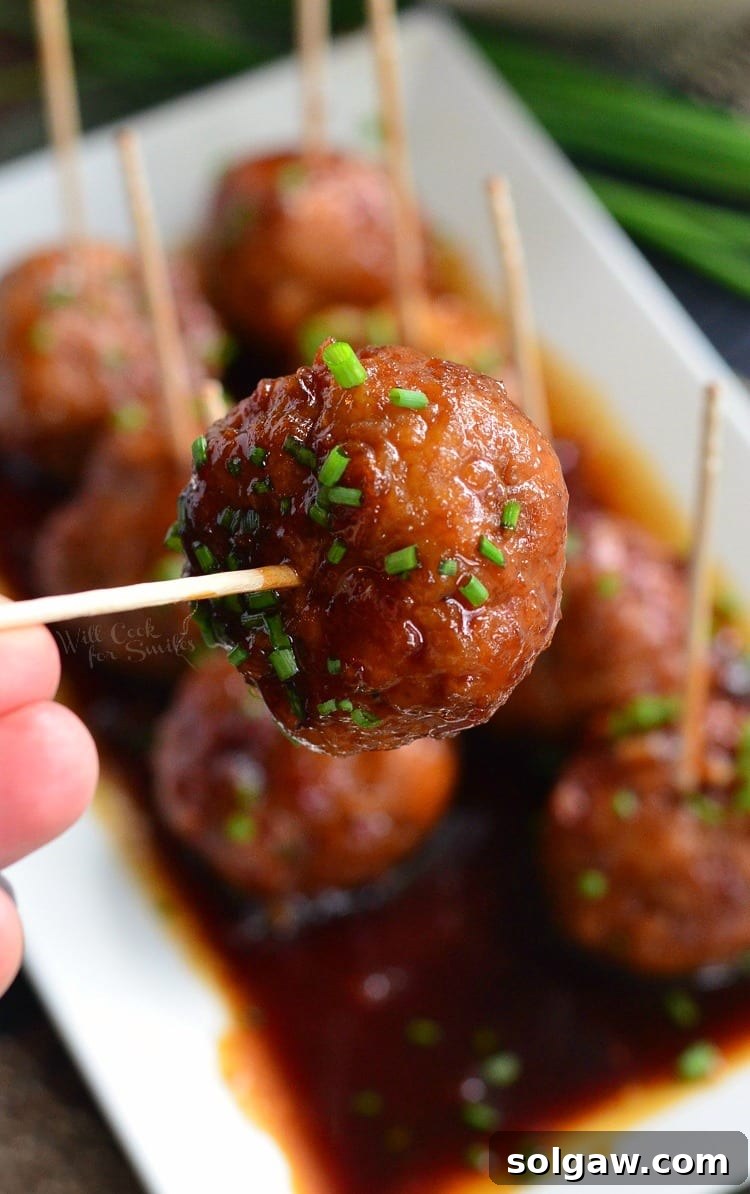 Appetizer-style Honey Garlic Teriyaki Chicken Meatballs served with toothpicks on a white tray