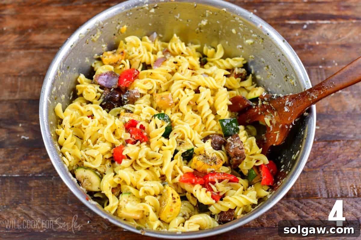 Smoky Grilled Veggie Pasta Salad 6 Mixing the ingredients in a large bowl with a wooden spoon for grilled vegetable pasta salad.