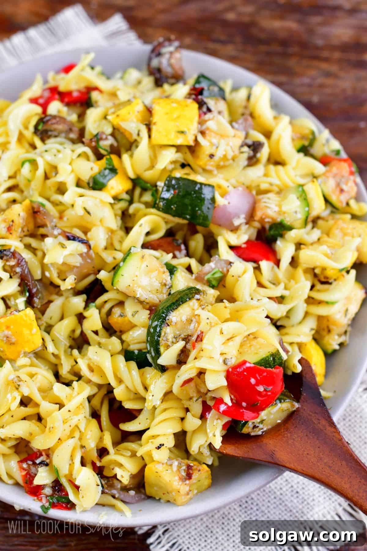 scooping up the Grilled Vegetable pasta salad with a big wooden spoon.