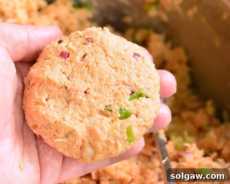 holding uncooked, shaped salmon patty