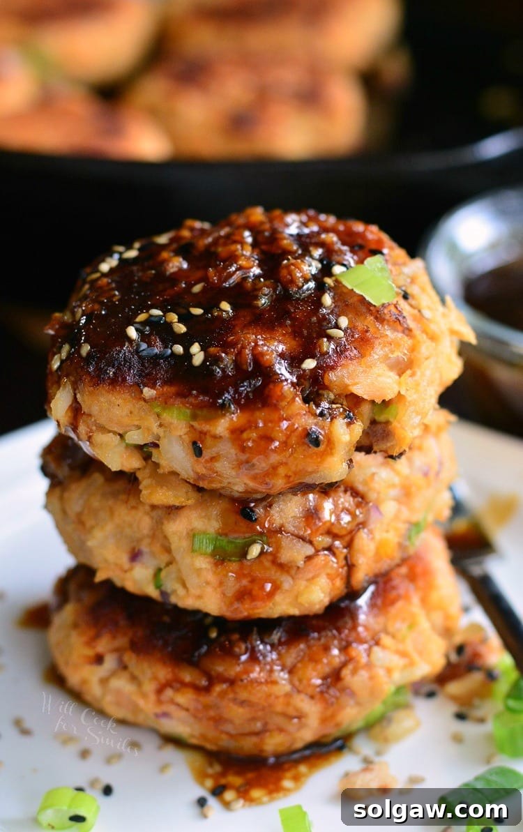 stacked cooked salmon patties topped with sauce