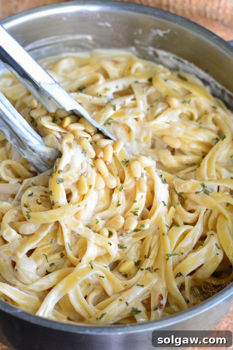 Roasted Garlic Asiago Fettuccine in a metal bowl with metal tongs 