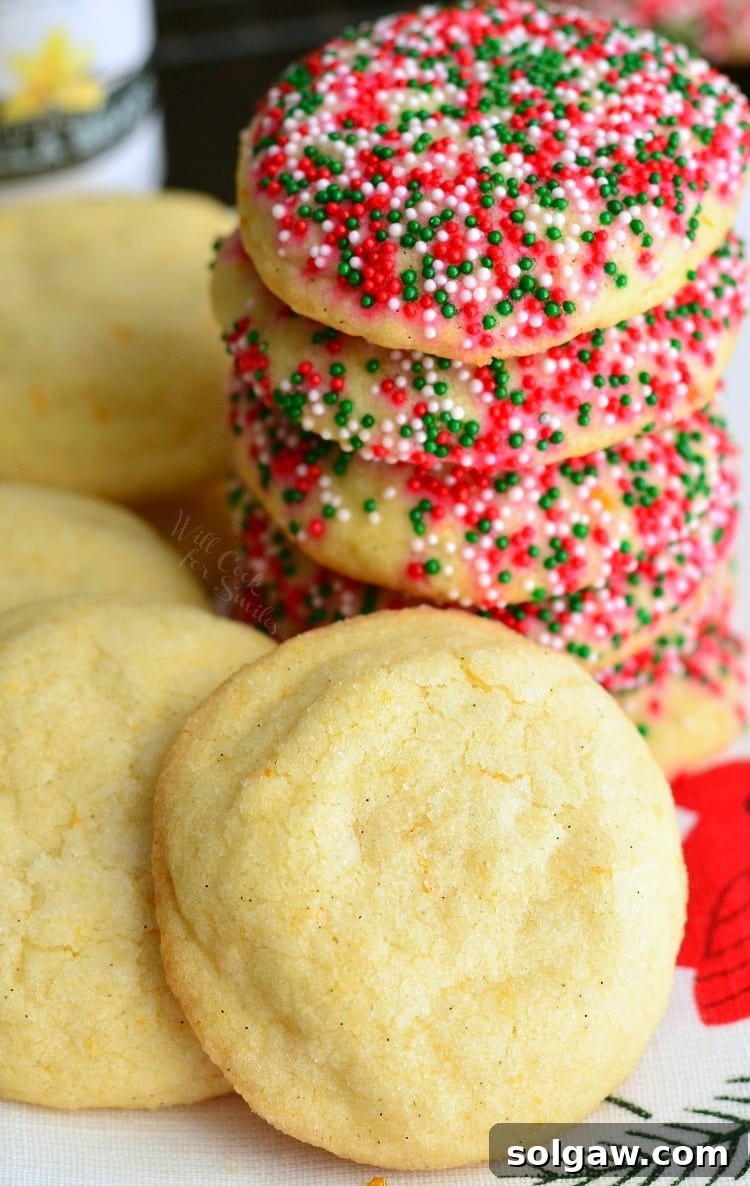 Zesty Orange & Vanilla Bean Sugar Cookies 2 Stacked homemade vanilla orange sugar cookies on a plate, some with colorful sprinkles