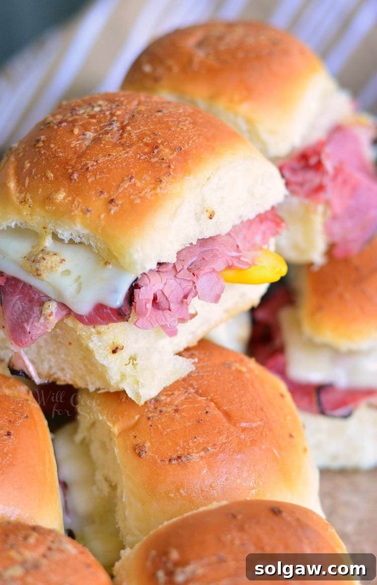 Hot Pastrami Sliders stacked up in a baking dish