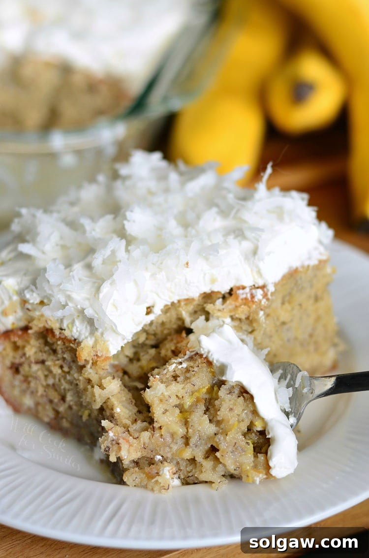 Lemon Coconut Banana Poke Cake with a slice removed