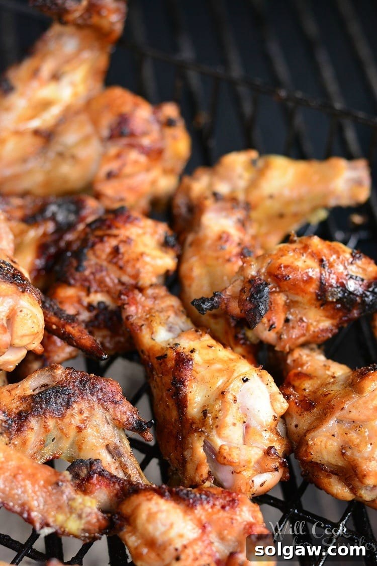 Chicken wings sizzling on a hot charcoal grill