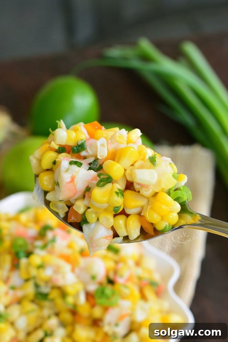 Cilantro Lime Shrimp Corn Salad in a bowl with a serving spoon scooping some out 