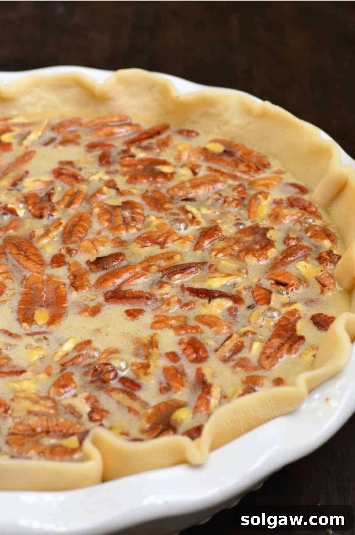 The assembled Pecan Pie, ready for baking in a pie crust shell within a pie baking dish.
