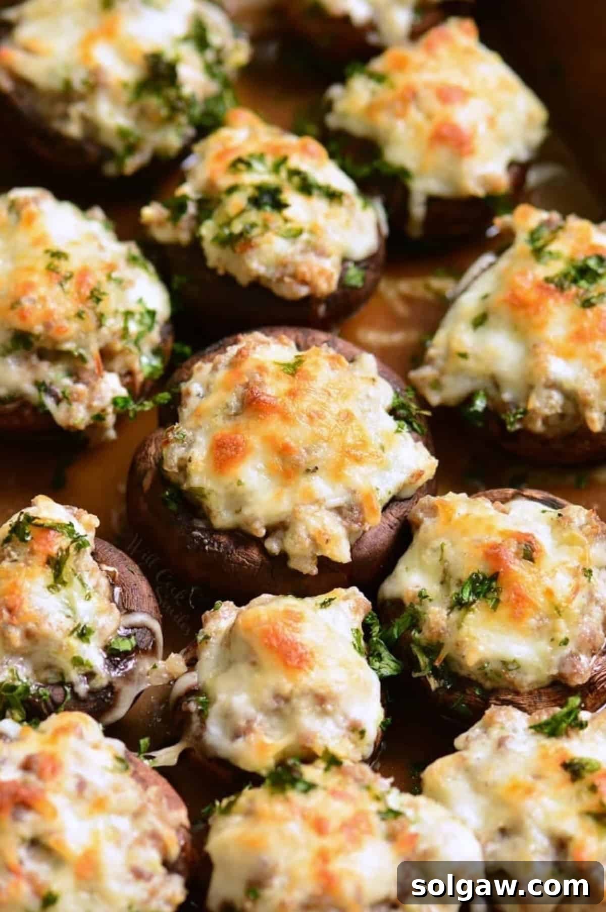 Several sausage stuffed mushrooms, perfectly baked and golden, arranged in a baking dish.