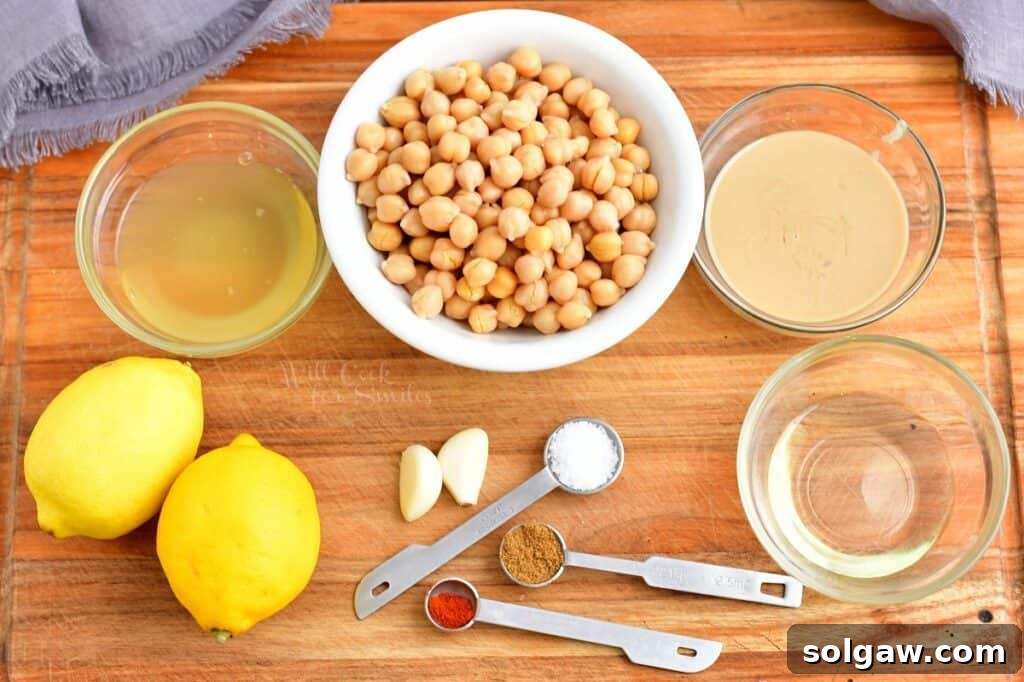 The ingredients for hummus are placed on a wooden cutting board.
