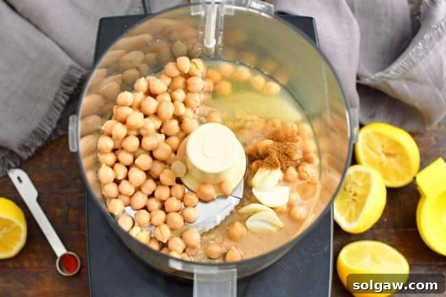 The ingredients for hummus are unblended in a food processor.
