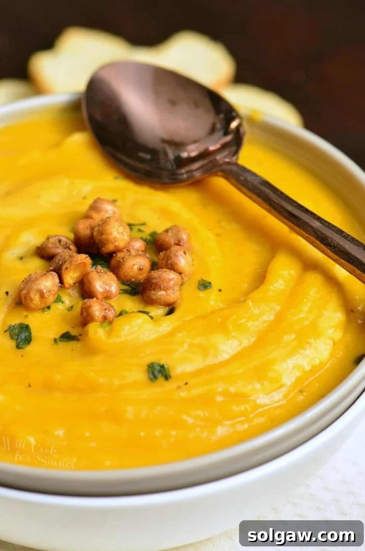 Creamy Instant Pot Butternut Soup 8 butternut squash in a bowl with chickpeas on and a spoon across the bowl.