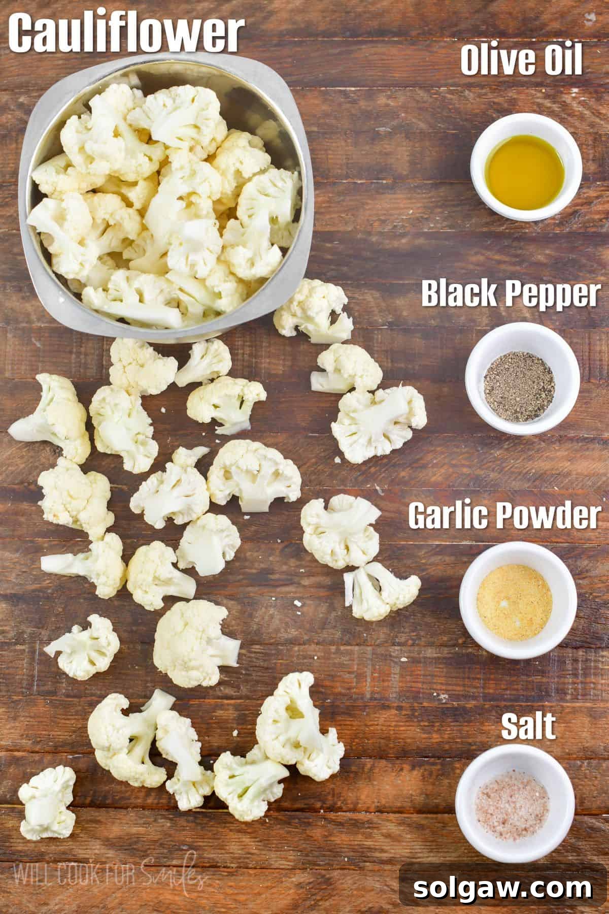 Labeled ingredients to make easy roasted cauliflower on a wooden board, including a head of cauliflower, olive oil, and spices.