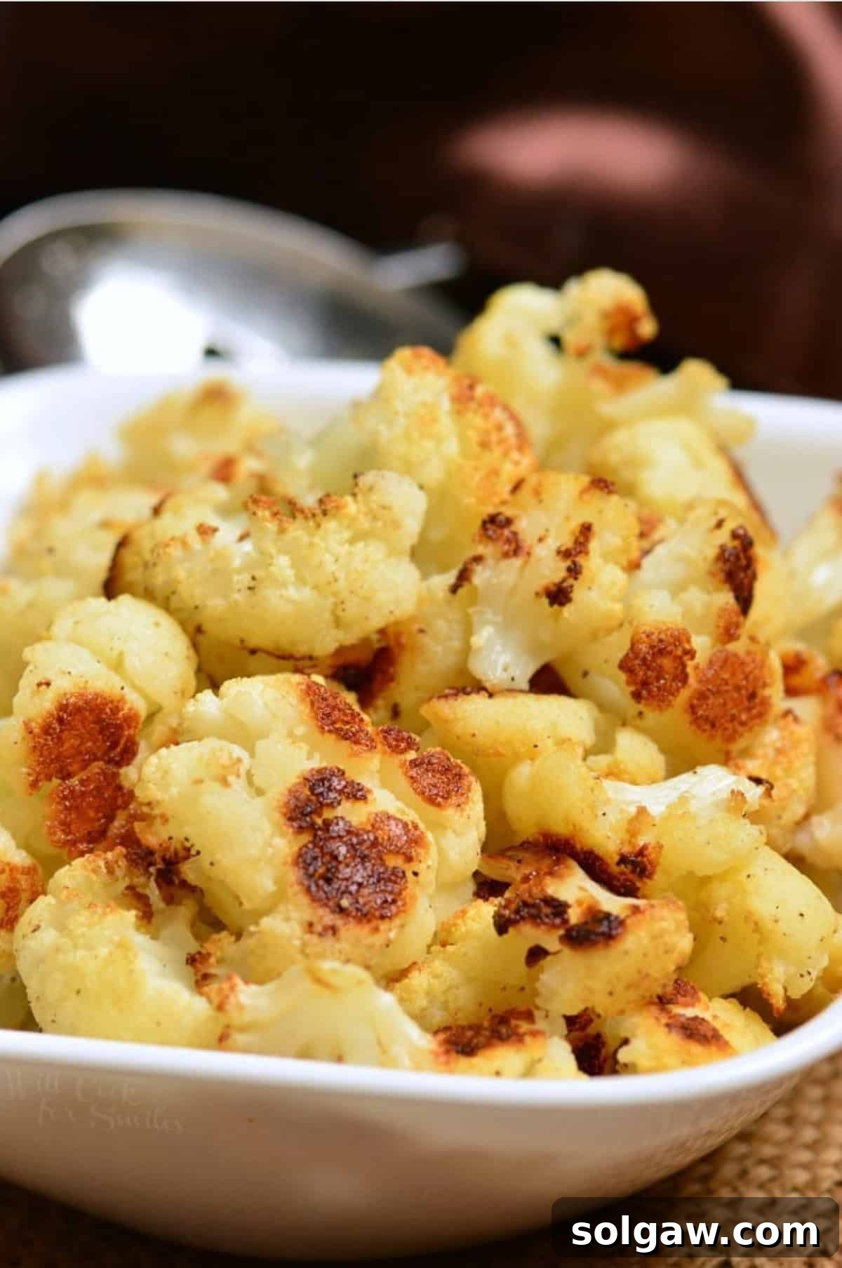 Roasted Cauliflower Florets in a serving bowl on a placemat, ready to enjoy.