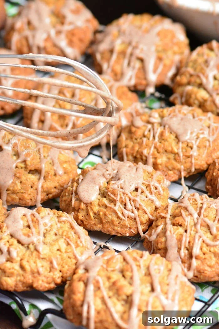 Close-up of glazed Cinnamon Oatmeal Cookies on a cooling rack, showcasing the topping.