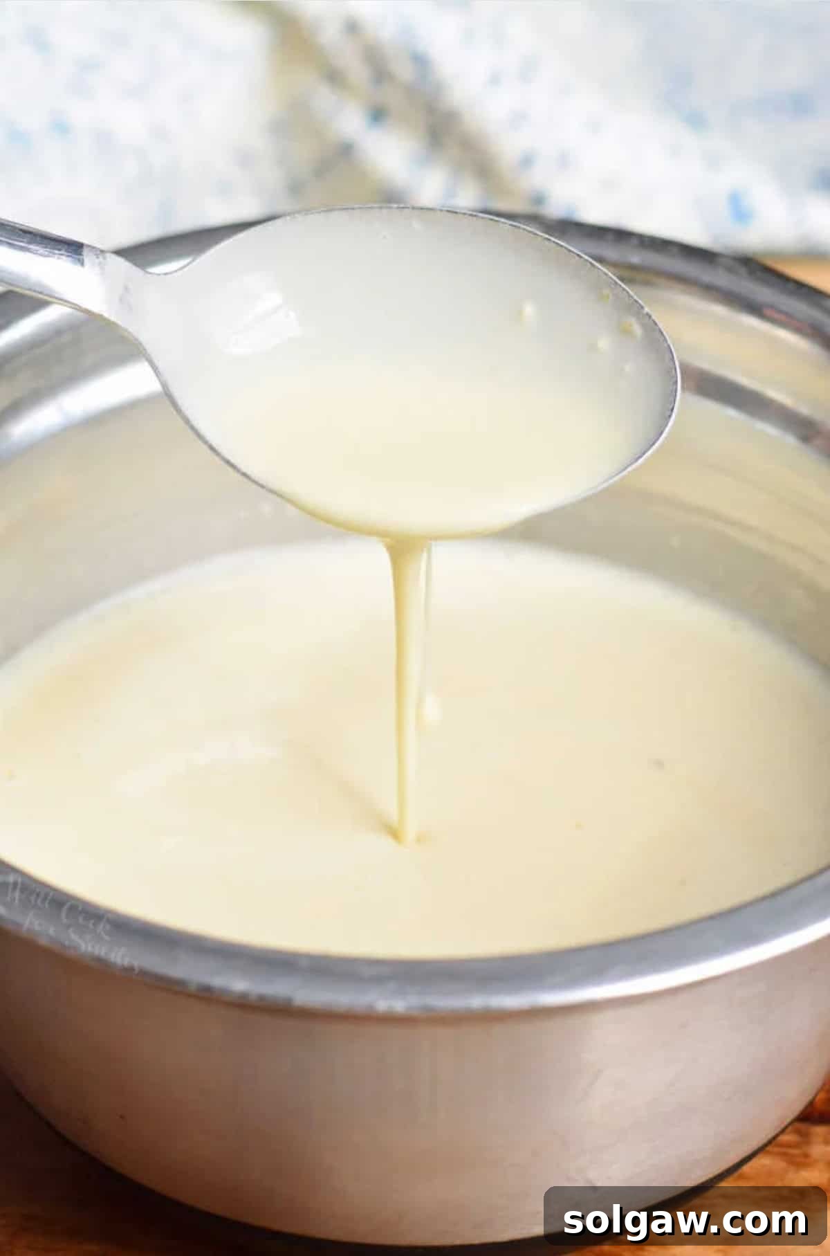 The Art of Perfect Crepes 3 Scooping thin crepe batter from a mixing bowl, showing the smooth consistency.