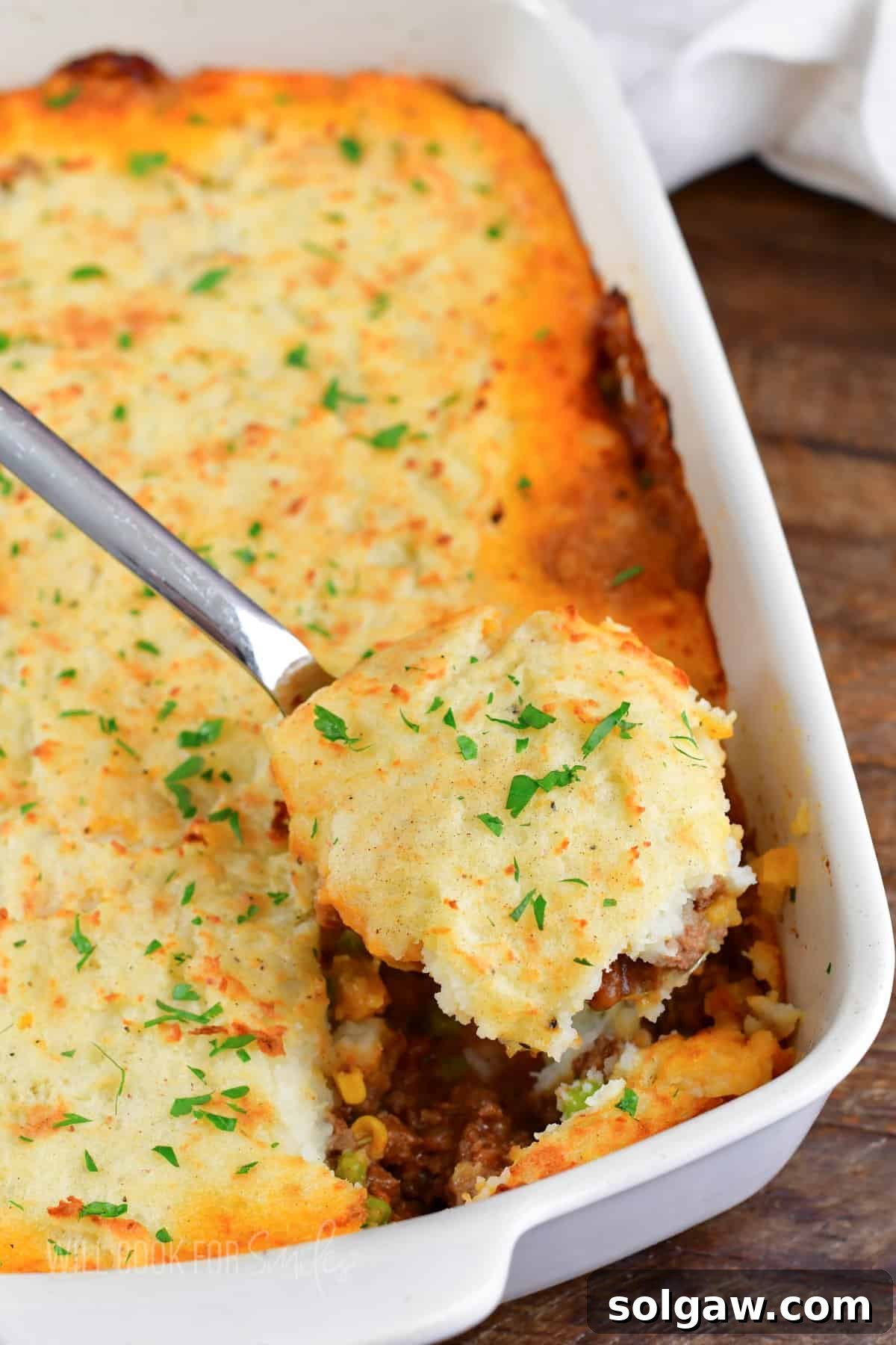 Hearty Shepherd's Pie: A Comfort Food Classic 3 scooping out some shepherd's pie from the baking dish.