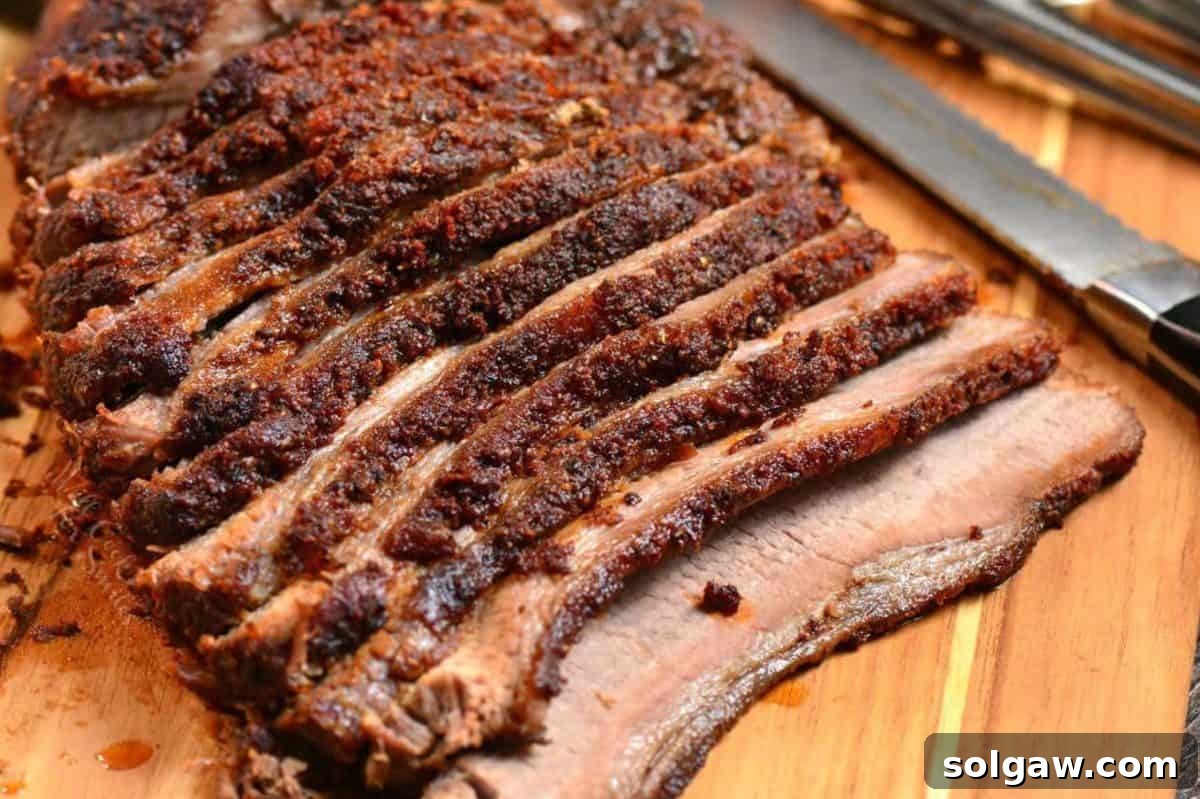 juicy and tender oven cooked beef brisket sliced against the grain on the cutting board.