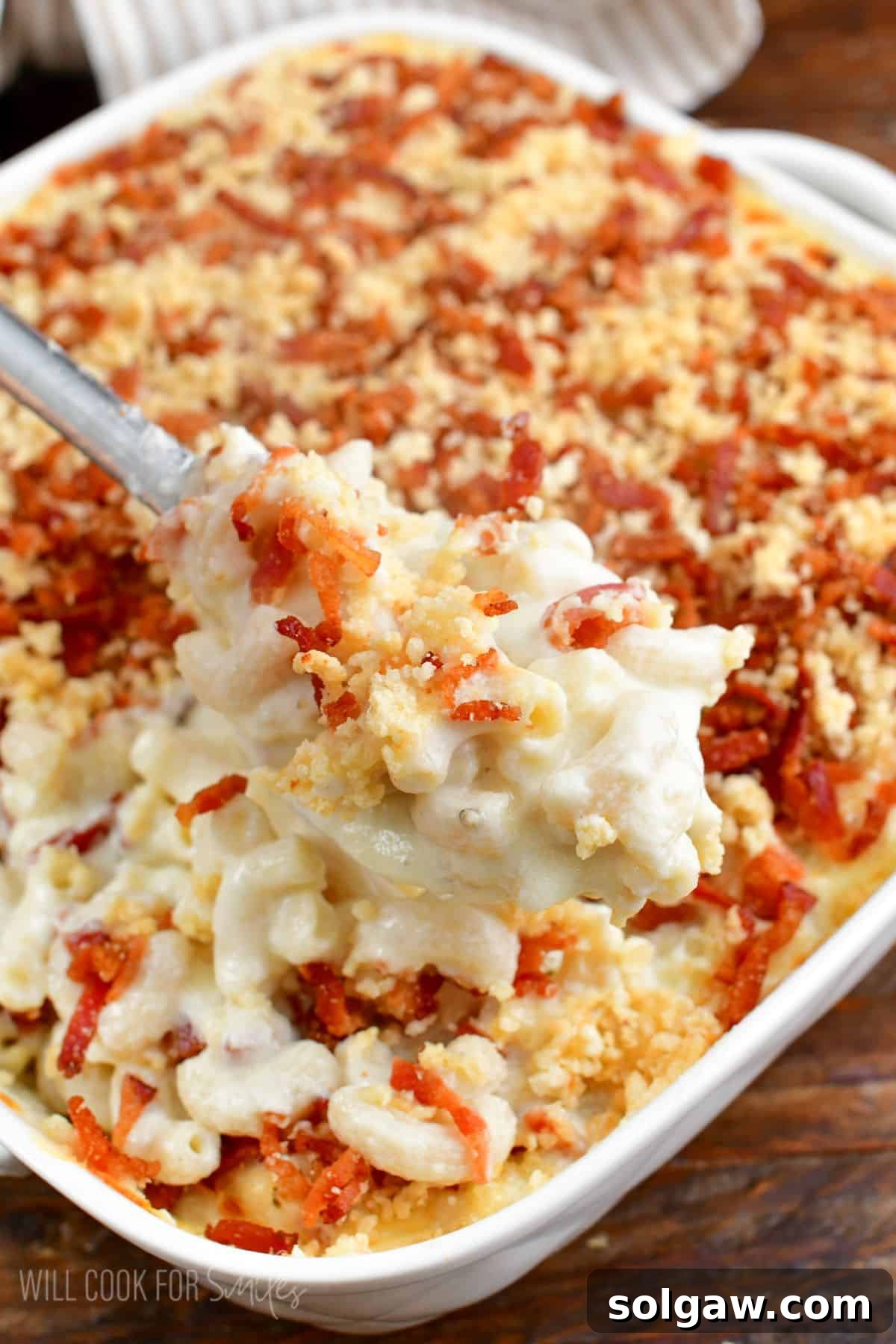 some baked mac and cheese scooped on a silver serving spoon.