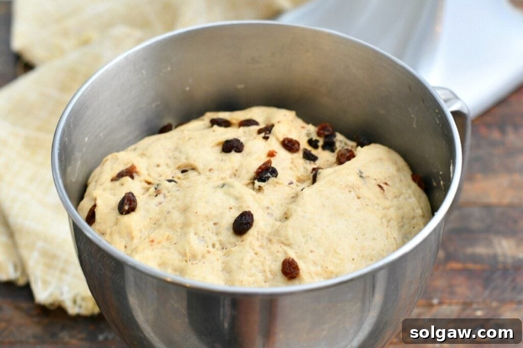 unbaked yeast dough rising in stainless steel mixing bowl