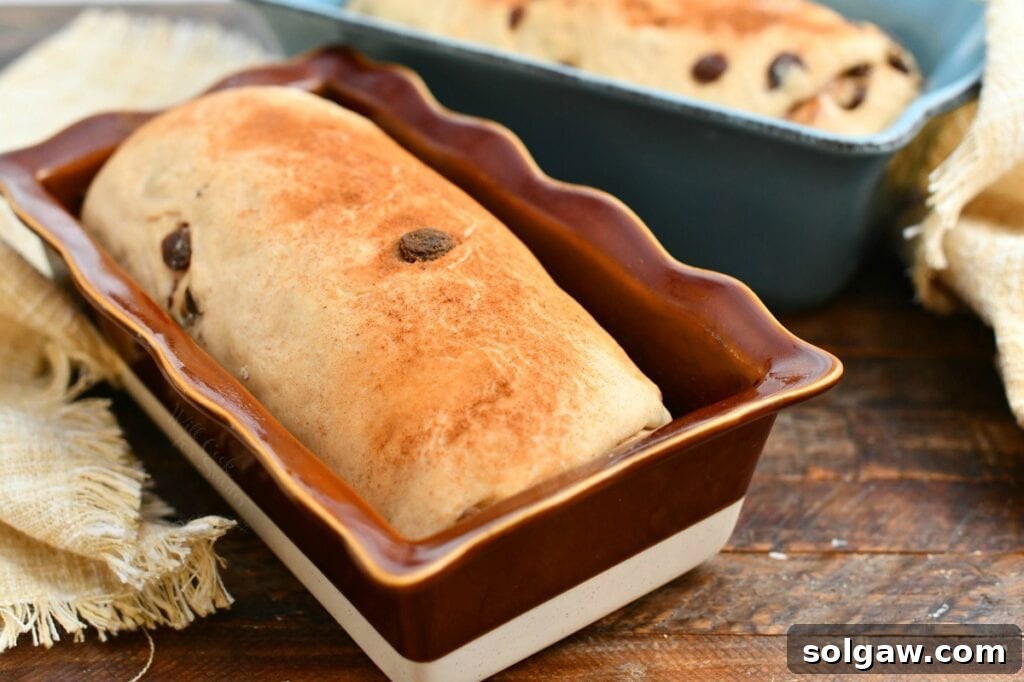 homemade loaf of yeast bread in red glazed stoneware loaf pan