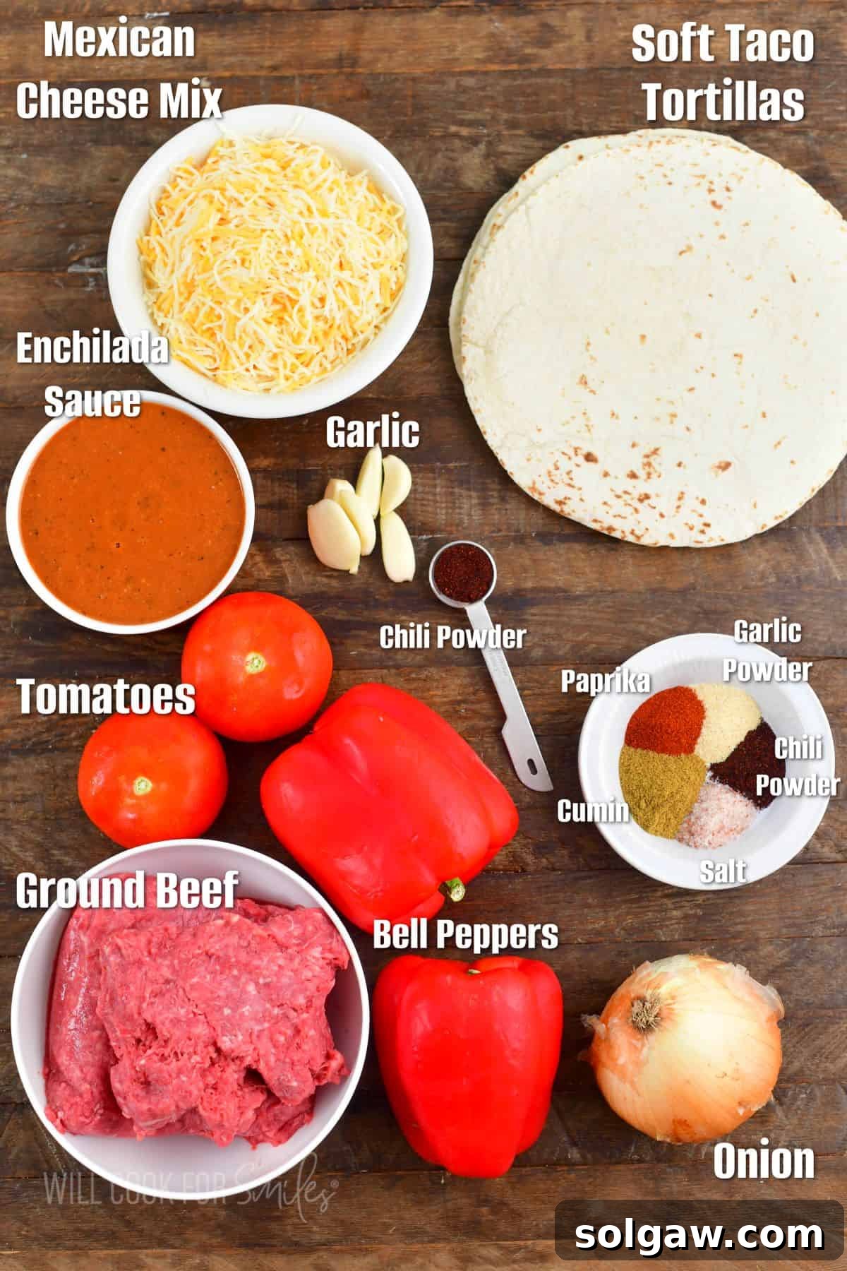 A carefully arranged display of labeled ingredients including onions, garlic, peppers, ground beef, spices, and tortillas, ready for making classic beef enchiladas from scratch.