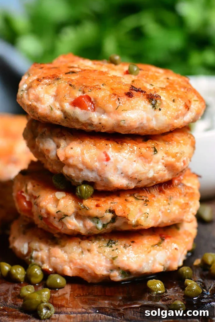 four salmon patties are stacked on top of each other.