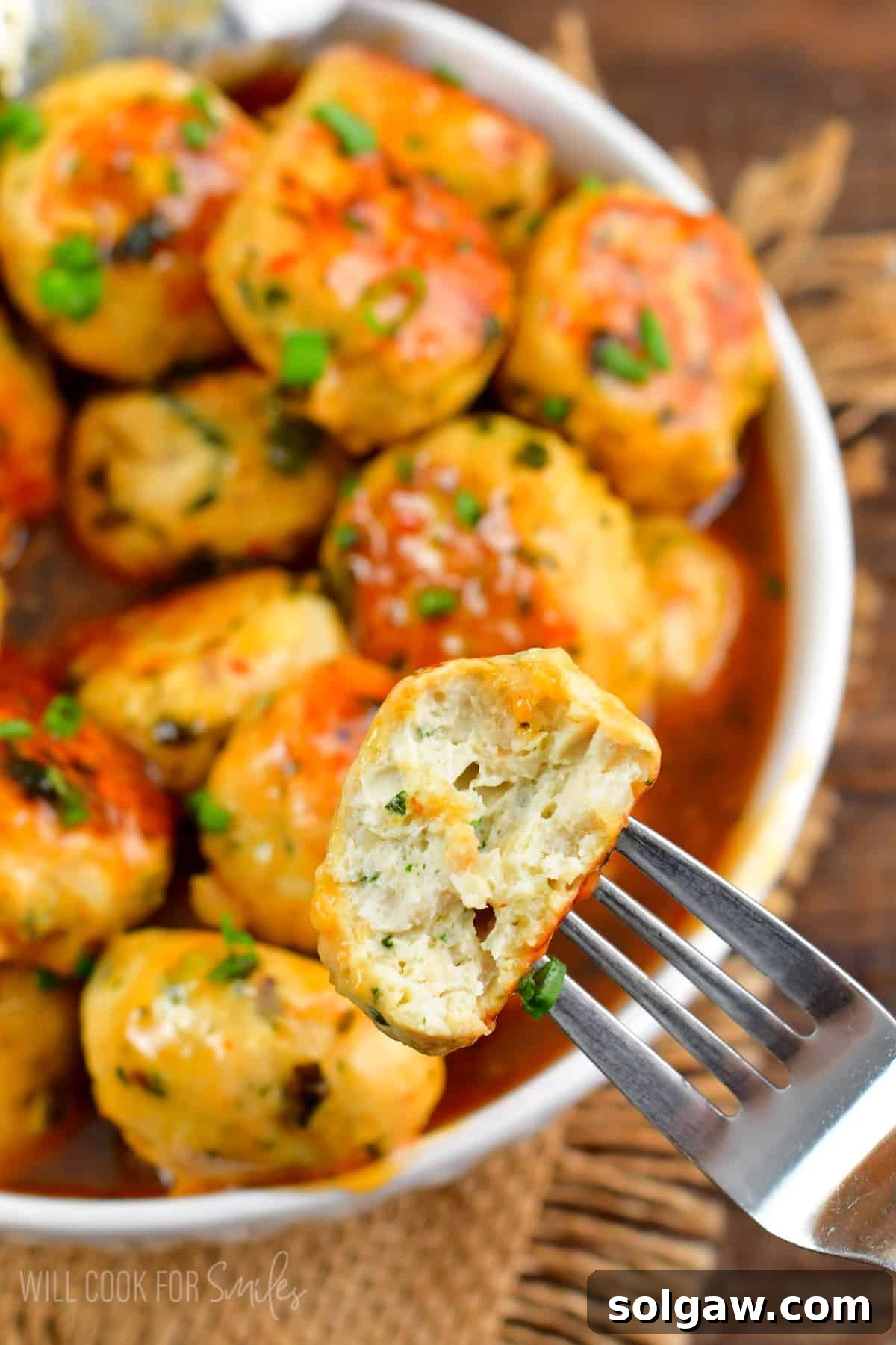 Sweet Chili Glazed Turkey Meatballs 10 meatball cut in half and on a fork with the rest of the meatballs in a bowl.