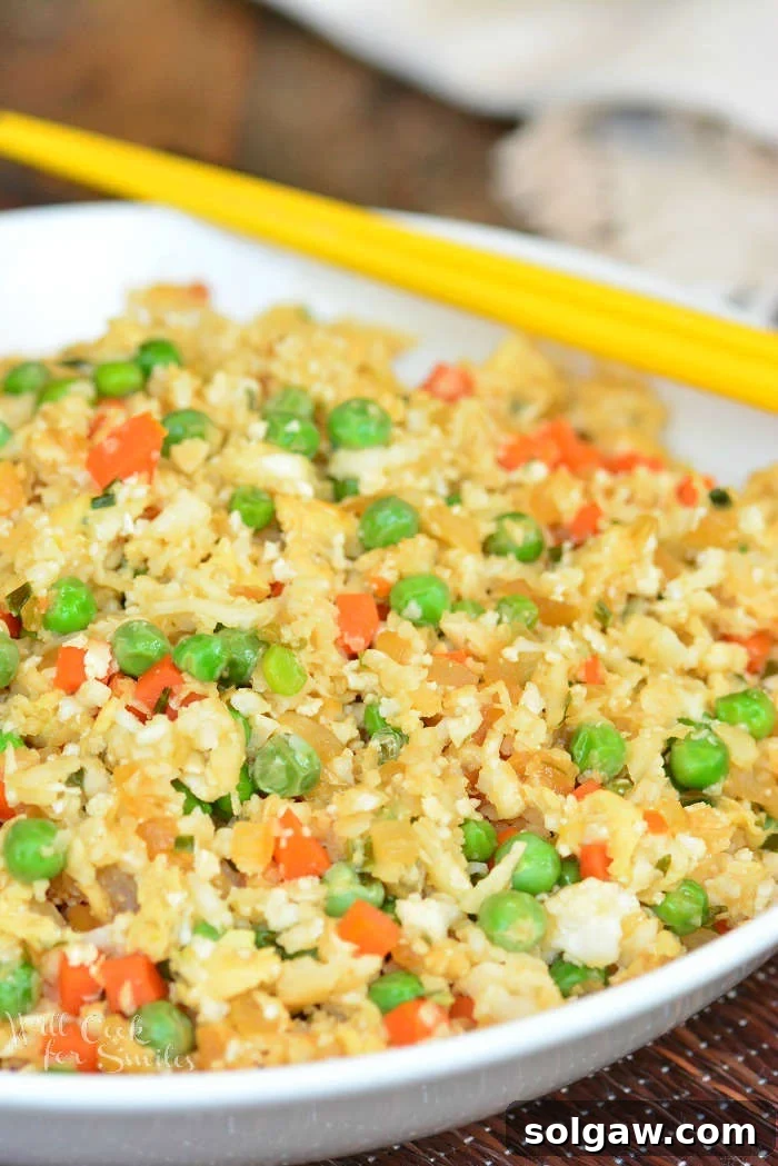 Cauliflower Fried Rice in a bowl with chop sticks 