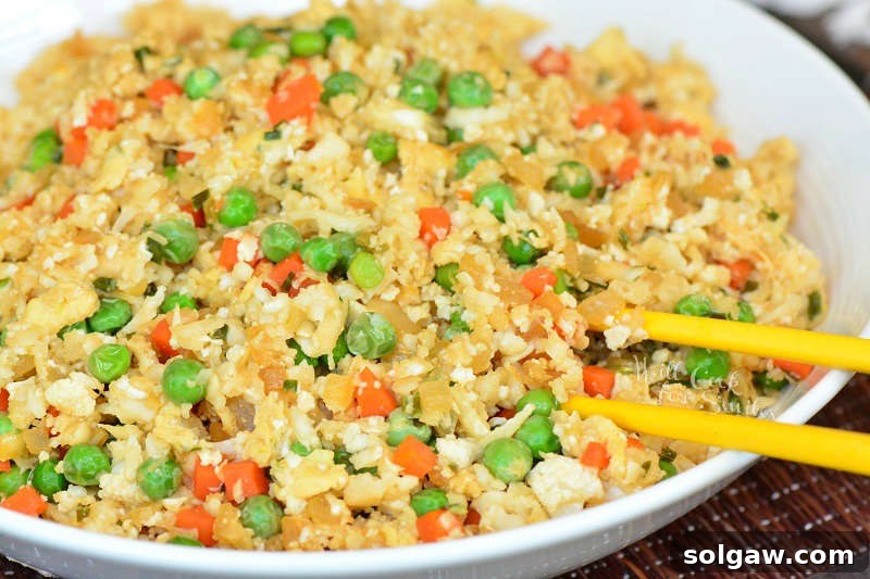 Cauliflower Fried Rice recipe in a bowl with chop sticks 